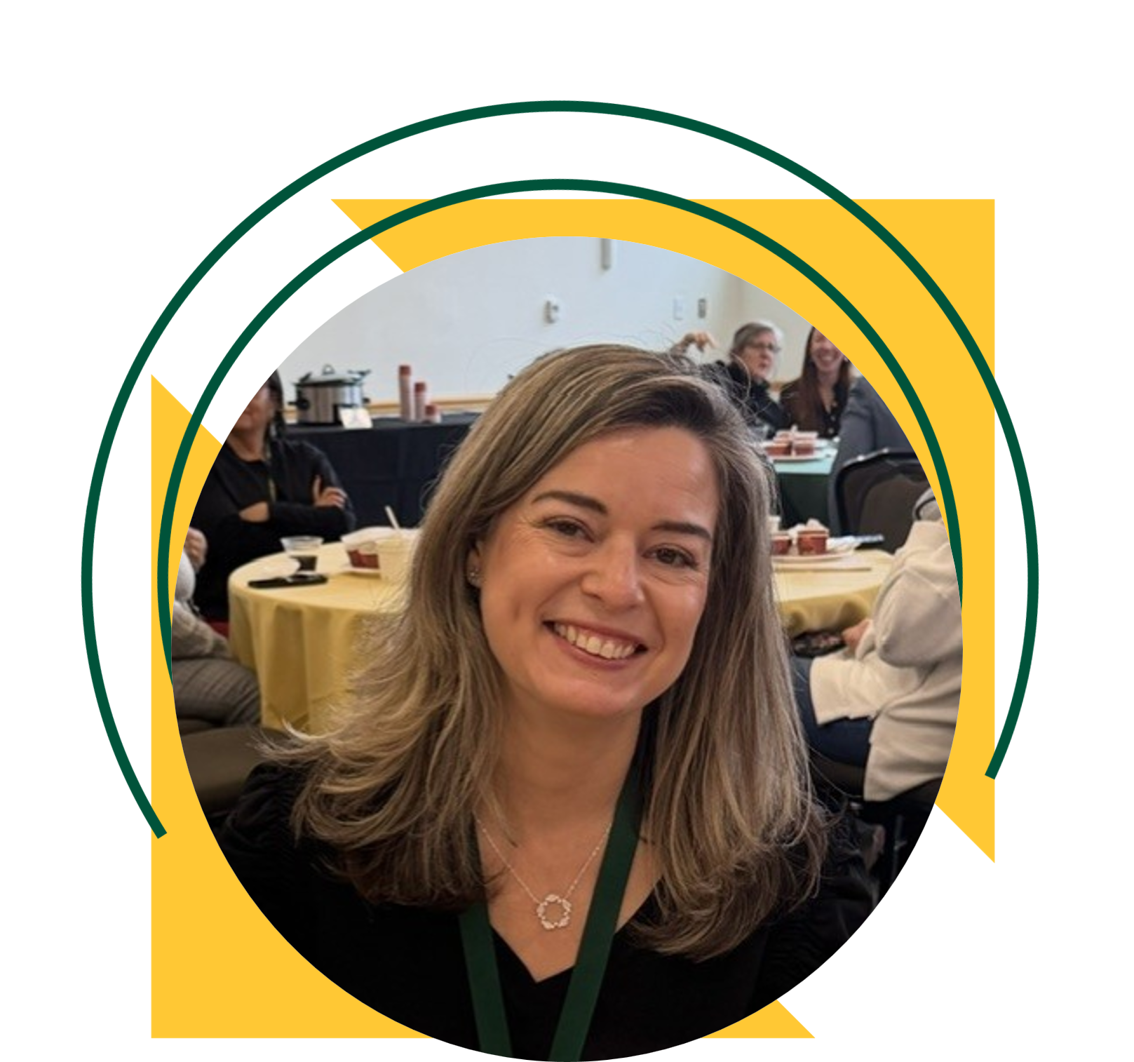 A woman wearing a black top and green lanyard smiles while seated at a round table. The portrait is framed within a circular design accented by yellow triangles and green curved graphic elements.